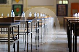 Exam examination room or hall set up ready for students to sit test. multiple desks tables and chairs. Education, school, student