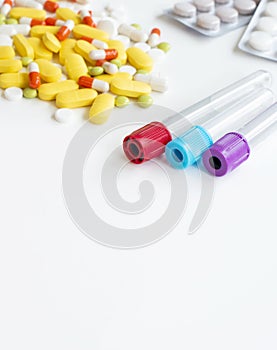 Examination conducting blood test tubes on a white table on a background with pills with place for text