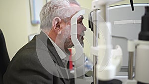 examination of the elderly man on the corneo topographer.modern clinic