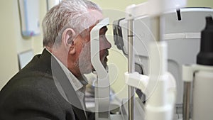 examination of the elderly man on the corneo topographer.modern clinic