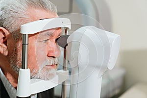 examination of elderly man on corneo topographer.modern clinic