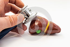 Examen de hígado. posesión estetoscopio en la mano gestión de un examen de hombre hígado formas de cerca. 