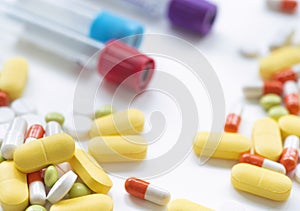 Examination of treatment control. Conducting blood test tubes on a white table with pills