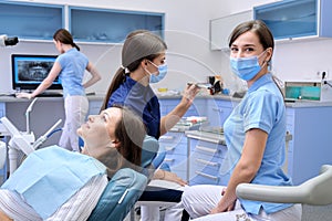 Examination, treatment of teeth, patient mature woman in dental chair