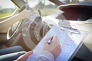 Examiner filling in driver`s license road test form