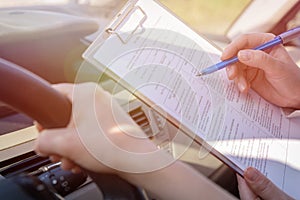 Examiner filling in driver`s license road test form