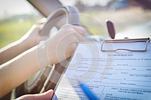 Examiner filling in driver`s license road test form