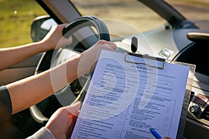 Examiner filling in driver`s license road test form