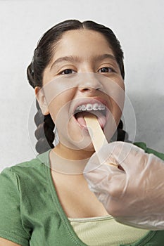 Examining Girl's Throat With Tongue Depressor
