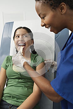 Examining Girl's Throat With Tongue Depressor photo