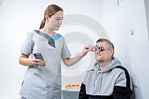 Examining patient vision. Eye exam. Optometrist checking patient eyesight and vision correction. Patient undergoing