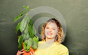 Examining a plant. teacher woman in glasses at biology lesson. environmental education. school nature study. happy