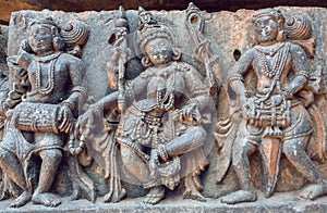 Example of ancient Indian architecture and relief, with drummer musicians and dancing Hindu goddess in temple in India