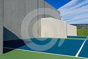 Photo of an outside American Handball courts with concrete wall, located at a park or school.