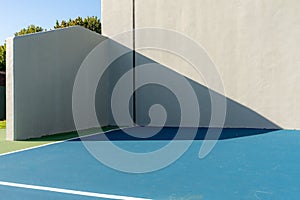 Photo of an outside American Handball courts with concrete wall, located at a park or school.