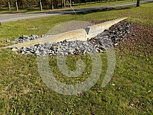 Example photo of a concrete v notch weir, level spreader, located adjacent to a highway swale.