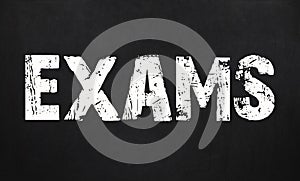 Exams / are written on a chalkboard. Blackboard