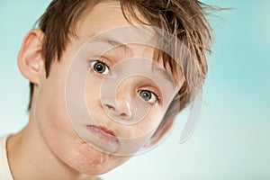 Exasperated young boy blowing out his cheeks photo