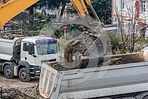 Exavator loading earth in the truck on construction site