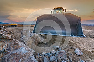 Excavadora moviendo piedra y roca en una cantera o en un sitio de construccionExcavator moving stone and rock in a quarry or at a photo