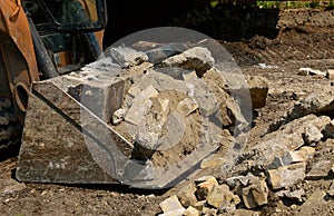 Excavating bucket full of concrete debris