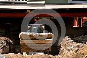 An excavating machine removing earth from under a house