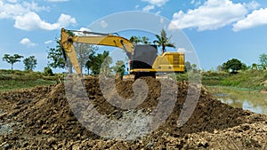 excavating soil into a dump truck to build a pond for store water for use in the dry season for agriculture