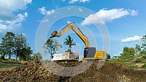 excavating soil into a dump truck to build a pond for store water for use in the dry season for agriculture