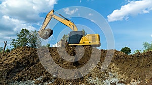 excavating soil into a dump truck to build a pond for store water for use in the dry season for agriculture