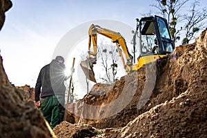 Excavation and earthwork at a construction site with a person and excavator