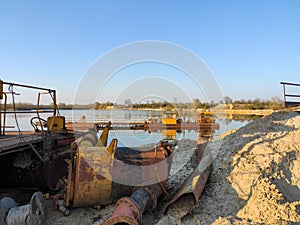 Excavation machine at earthmoving work in sand quarry. Extraction of sand from a lake.