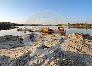 Excavation machine at earthmoving work in sand quarry. Extraction of sand from a lake.