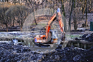 Excavation in the park. Excavator working on the lake.