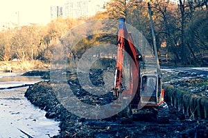 Excavation in the park. Excavator working on the lake.