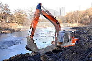 Excavation in the park. Excavator working on the lake.