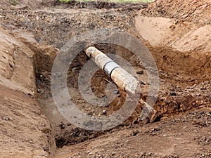 Excavation pit. Old drink water pipe with stainless repairing sleeve members.