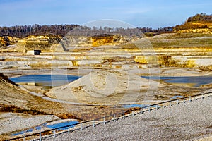 Excavation site, mounds, a pond with blue water in the old marl quarry mine
