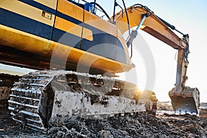 Excavation work. Excavator at construction site with sunset