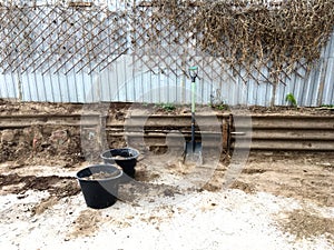 Excavation work on a personal plot with buckets and a shovel.