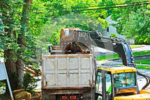 excavator arm with bucket full of dirt at construction site