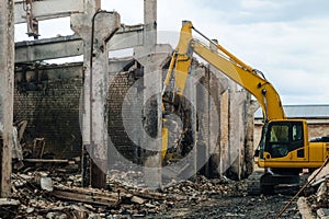 Excavator with attachment steel grappling hydraulic pliers in collapsed industrial building