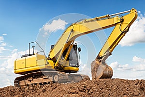 Excavator backhoe on the ground at construction site in blue sky background