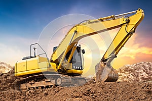 Excavator backhoe on the ground at construction site in sunset background