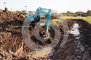 excavator backhoe working in the digging a soil to adjust the postharvest areas in the rice fields. agriculture machinery for