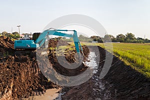 excavator backhoe working in the digging a soil to adjust the postharvest areas in the rice fields. agriculture machinery for