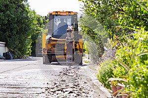 Excavator breaking and drilling the concrete road for repairing. Large pneumatic hammer mounted on the hydraulic arm of a construc