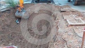 Excavator bucket digging a hole at construction site