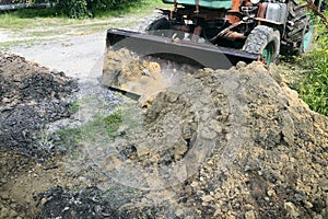 Excavator bucket digging a trench in the dirt ground