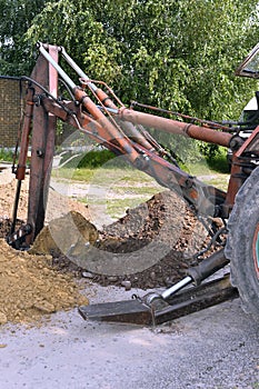 Excavator bucket digging a trench in the dirt ground