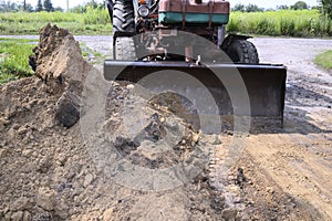 Excavator bucket digging a trench in the dirt ground